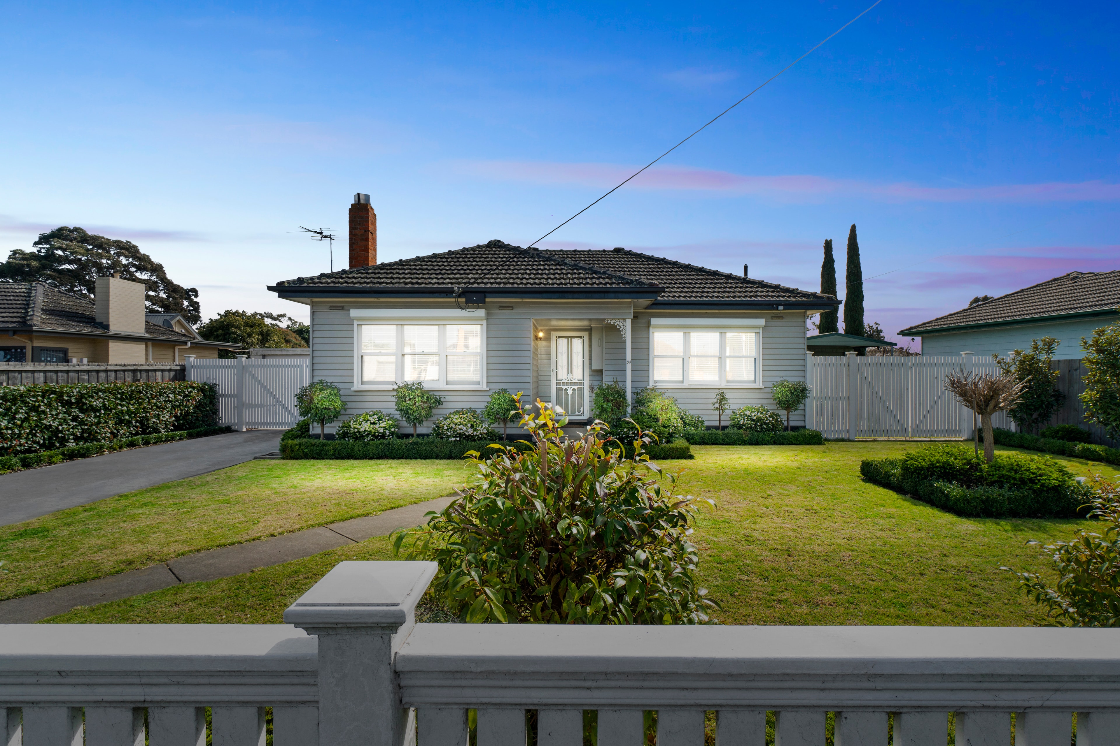 White cottage home with manicured garden