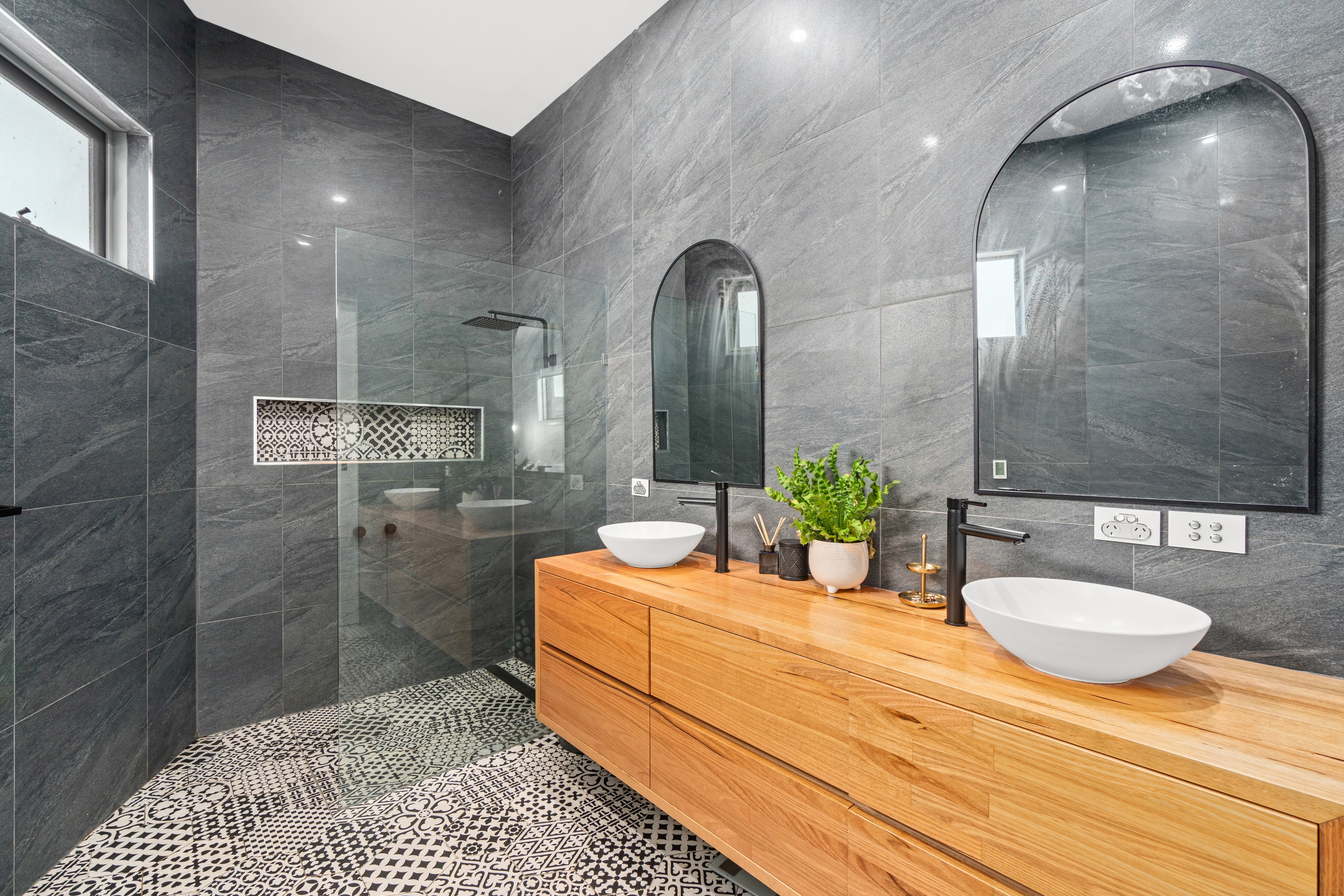 Luxury ensuite with stone tiles, timber vanity and twin vessel basins